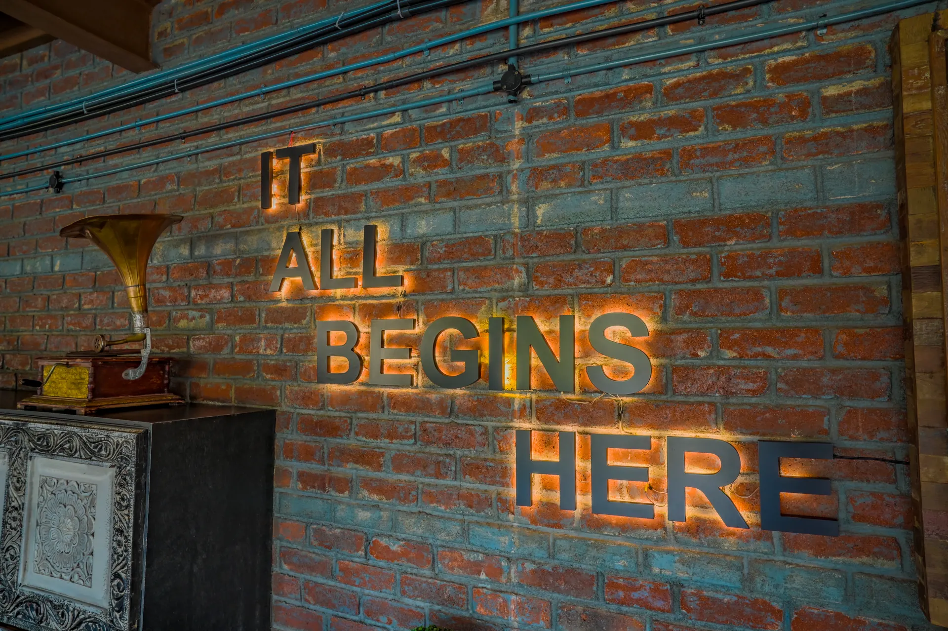It All Begins Here illuminated brick-wall sign at Mysore Union Mysore