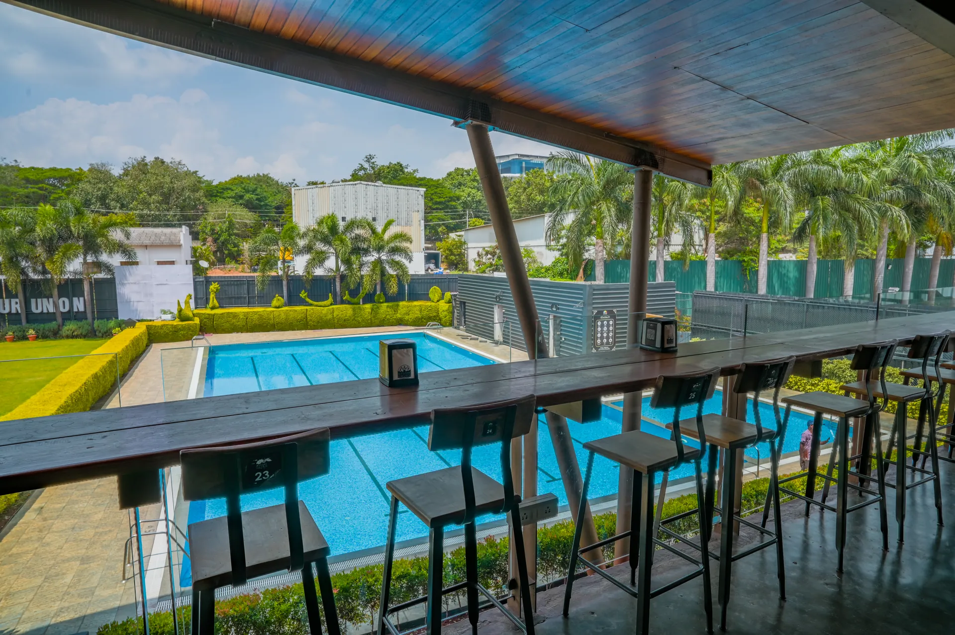 Swimming pool and outdoor bar seating at Mysore Union restaurant in Mysuru